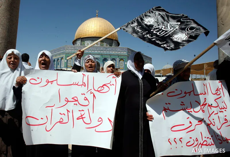 Palestinians wave flags and shout slogans during a protest against an anti-Islam movie made in the U.S. and French cartoons said to insult the Prophet Muhammad in Jerusalem's Old City, Sept. 21, 2012. Photo by Mahfouz Ab...