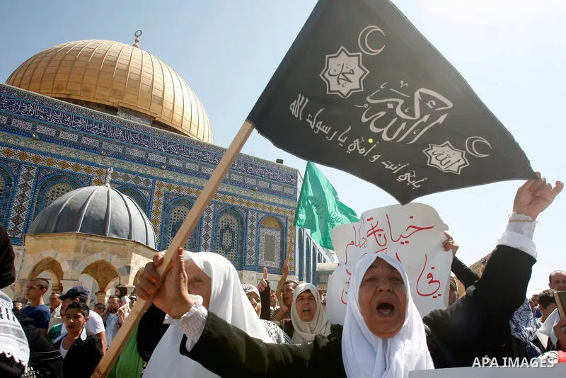 Palestinians wave flags and shout slogans during a protest against an anti-Islam movie made in the U.S. and French cartoons said to insult the Prophet Muhammad in Jerusalem's Old City, Sept. 21, 2012. Photo by Mahfouz Ab...