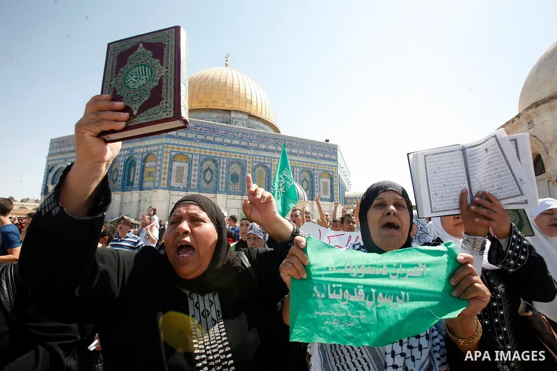 Palestinians wave flags and shout slogans during a protest against an anti-Islam movie made in the U.S. and French cartoons said to insult the Prophet Muhammad in Jerusalem's Old City, Sept. 21, 2012. Photo by Mahfouz Ab...