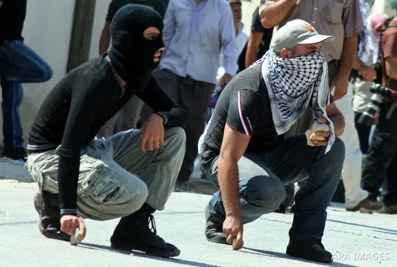 Palestinian protesters throw stones at Israeli soldiers during a demonstration against the expropriation of Palestinian land by Israel in the village of Kfar Qaddum, near the West Bank city of Nablus, on september 21, 20...