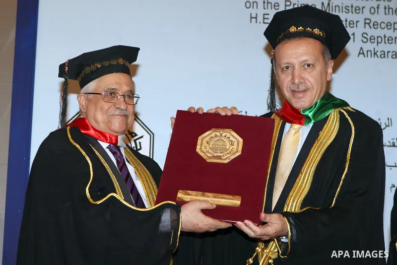 Turkish Prime Minister Recep Tayyip Erdogan (R) poses with president of Palestine Mahmoud Abbas as he receives an honorary doctorate degree from Palestine's Al-Quds University in Ankara on September 21, 2012. Photo by Th...