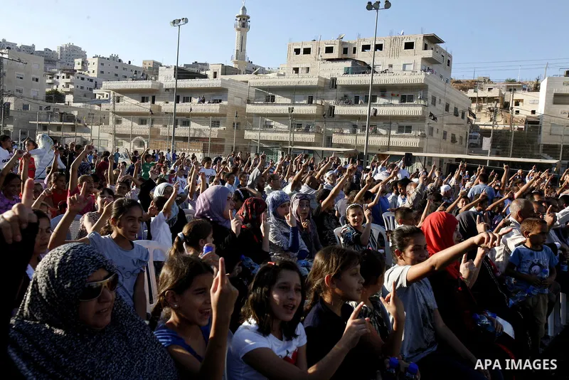 Palestinians chant slogans during a gathering denouncing an US-produced amateur film mocking Islam's Prophet Mohammed and cartoons published in a French satirical magazine Charlie Hebdo, in the Issawiya district of Arab...