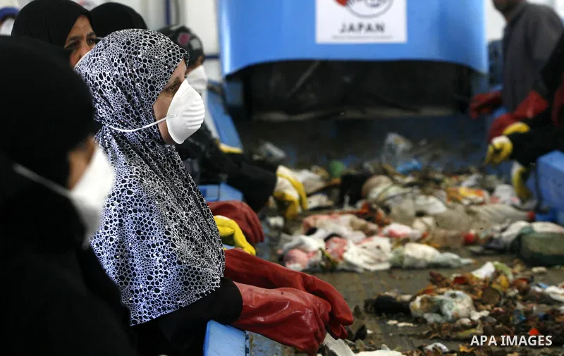 Palestinian women sort solid waste for production compost in station in Rafah in the southern Gaza Strip, on Sep. 23, 2012 Some Palestinians, driven by poverty exacerbated by the Israeli blockade and lack of employment o...