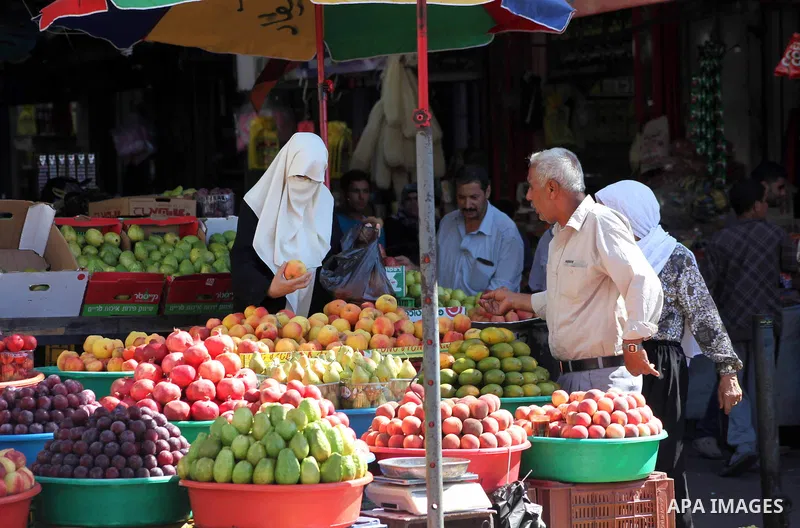A Palestinian woman buys fruits at a market in Gaza city, Sept. 23, 2012. The ministry of Agriculture in Gaza government decided stop import fruits from Israel except apples and bananas to support the local fruits produc...