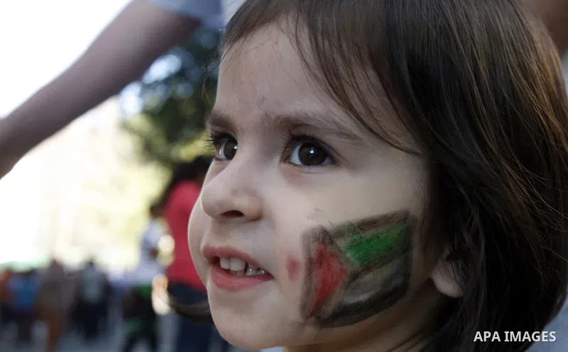 A Palestinian girl attends the Jerusalemite cakes festival in al-Sheikh Jarrah neighborhood in the east of Jerusalem city, on 23 September 2012. Photo by Mahfouz Abu Turk