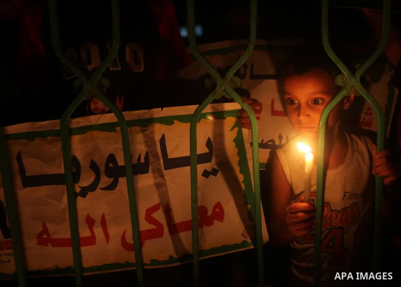 A Palestinian boy holds a candle during a rally to show solidarity with Syrian mothers and children who suffer most in civil war, in Jabalia refugee camp northen Gaza strip, September 24, 2012. The UN Security Council sh...