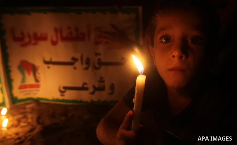 A Palestinian boy holds a candle during a rally to show solidarity with Syrian mothers and children who suffer most in civil war, in Jabalia refugee camp northen Gaza strip, September 24, 2012. The UN Security Council sh...