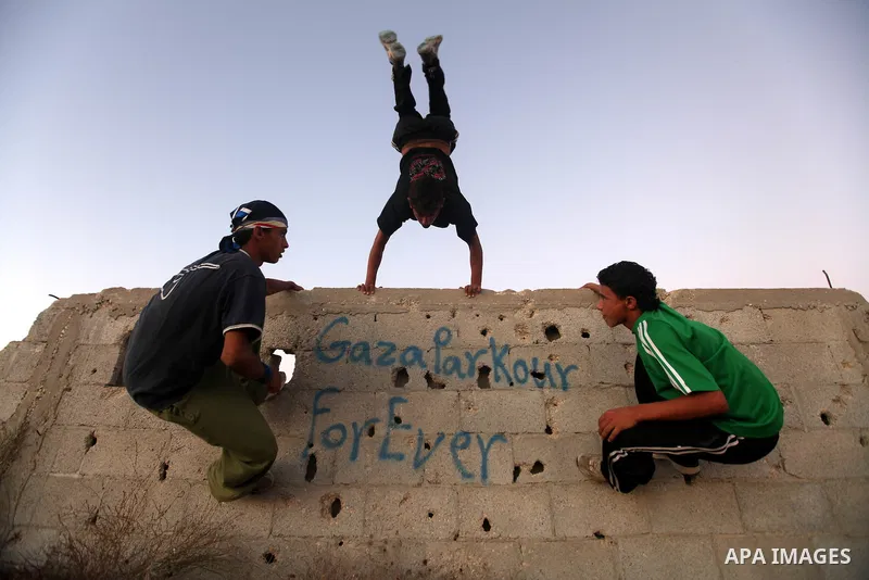 Palestinian youths practice their parkour skills in Khan Younis in southern Gaza Strip on 24 September 2012. Parkour originating in France is the physical practice of traversing elements in both urban and rural settings...