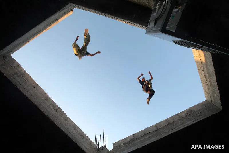 Palestinian youths practice their parkour skills in Khan Younis in southern Gaza Strip on 24 September 2012. Parkour originating in France is the physical practice of traversing elements in both urban and rural settings...