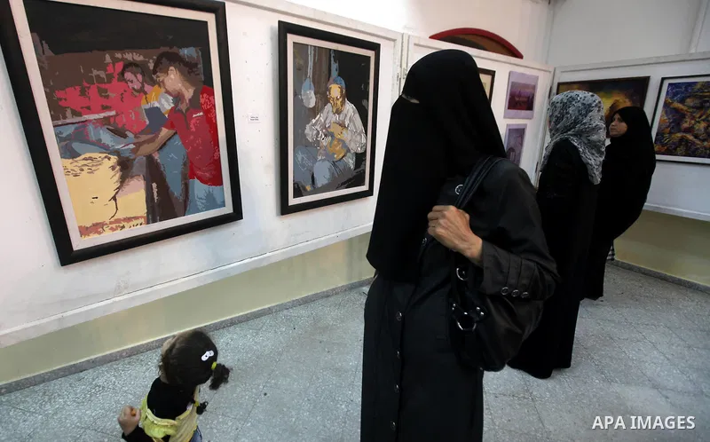 Palestinians look at paintings during an abstract painting show in Gaza city, on 24 September 2012. Photo by Majdi Fathi