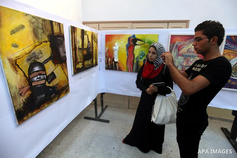 Palestinians look at paintings during an abstract painting show in Gaza city, on 24 September 2012. Photo by Majdi Fathi