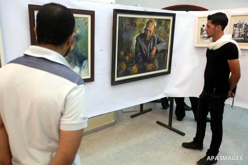 Palestinians look at paintings during an abstract painting show in Gaza city, on 24 September 2012. Photo by Majdi Fathi