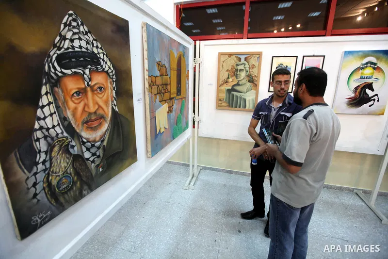 Palestinians look at paintings during an abstract painting show in Gaza city, on 24 September 2012. Photo by Majdi Fathi