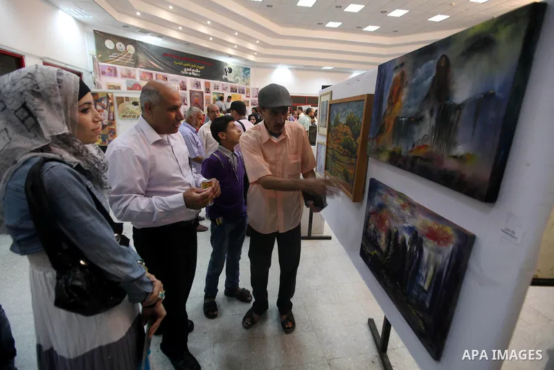 Palestinians look at paintings during an abstract painting show in Gaza city, on 24 September 2012. Photo by Majdi Fathi