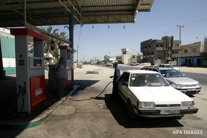 Palestinians wait to fill containers with fuel from a petrol station in Rafah in the southern Gaza Strip, on Sep. 25, 2012, as the Palestinian authority calls on Egypt to provide more fuel. Photo by Eyad Al Baba