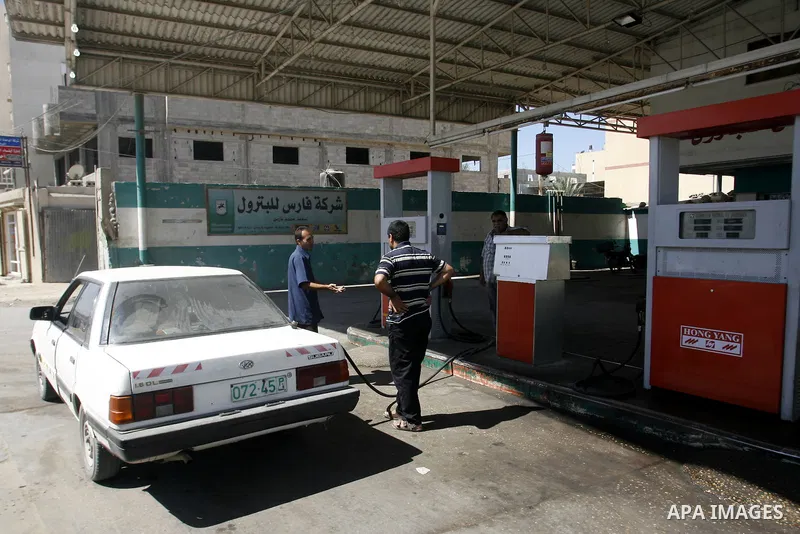 Palestinians wait to fill containers with fuel from a petrol station in Rafah in the southern Gaza Strip, on Sep. 25, 2012, as the Palestinian authority calls on Egypt to provide more fuel. Photo by Eyad Al Baba