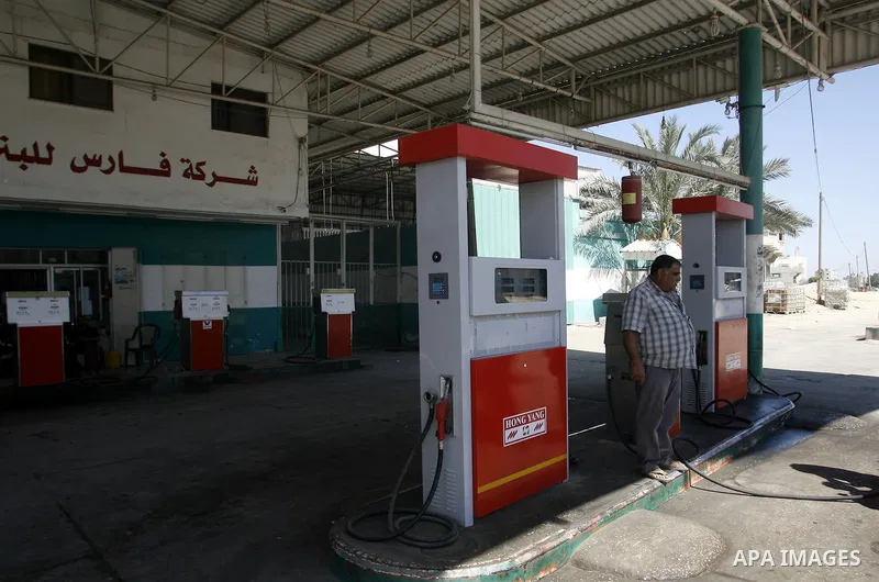 Palestinians wait to fill containers with fuel from a petrol station in Rafah in the southern Gaza Strip, on Sep. 25, 2012, as the Palestinian authority calls on Egypt to provide more fuel. Photo by Eyad Al Baba
