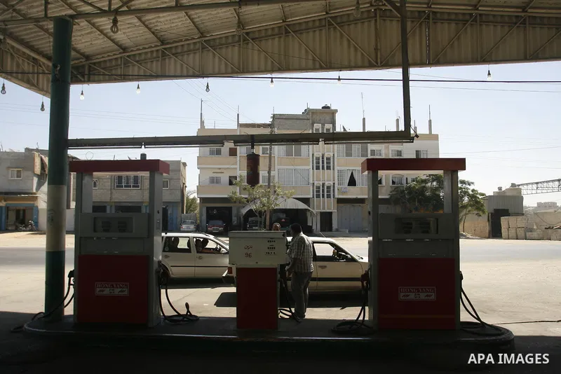 Palestinians wait to fill containers with fuel from a petrol station in Rafah in the southern Gaza Strip, on Sep. 25, 2012, as the Palestinian authority calls on Egypt to provide more fuel. Photo by Eyad Al Baba