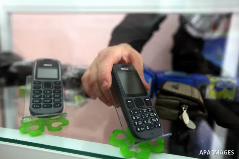 Palestinian Fatma al-Halouli displays a cell phone at her shop in Gaza city on 25 September 2012. The International Monetary Fund (IMF) noted that growth has slowed and unemployment risen in both the West Bank and the Ga...