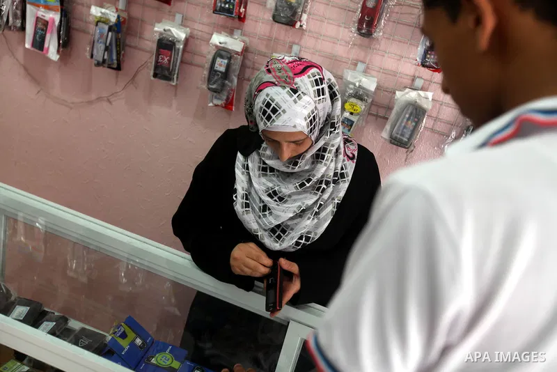 Palestinian Fatma al-Halouli repairs a cell phone at her shop in Gaza city on 25 September 2012. The International Monetary Fund (IMF) noted that growth has slowed and unemployment risen in both the West Bank and the Gaz...