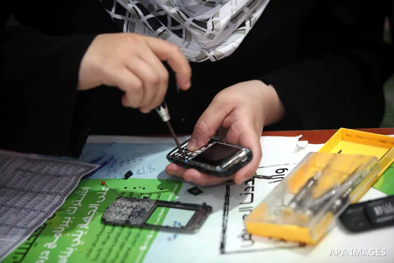Palestinian Fatma al-Halouli repairs a cell phone at her shop in Gaza city on 25 September 2012. The International Monetary Fund (IMF) noted that growth has slowed and unemployment risen in both the West Bank and the Gaz...