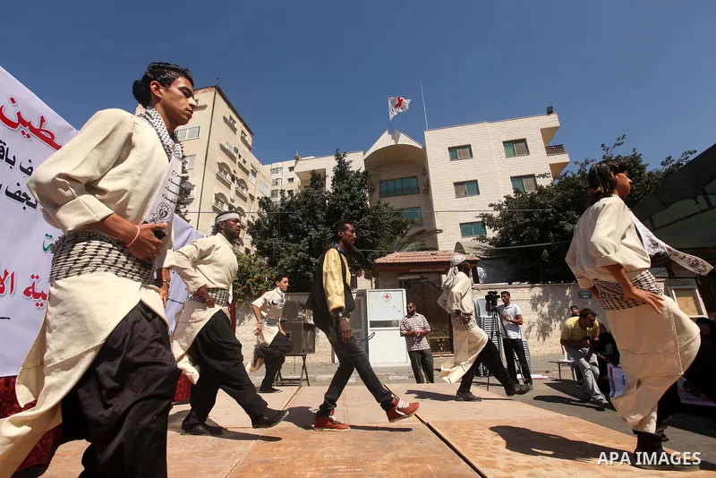 Palestinians perform traditional dances in front of the red cross office during a ceremony to support the prisoners in Israeli jails, in Gaza city on 26 September 2012. Photo by Majdi Fathi