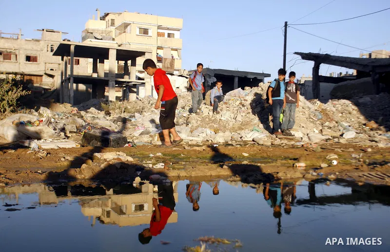 Palestinian children stand near an erupting sewage pipeline, in Rafah refugee camp southern the Gaza strip, Sept 26, 2012. In the aftermath of the Israeli military Operation Cast Lead in 2008/2009, Palestinian refugees i...