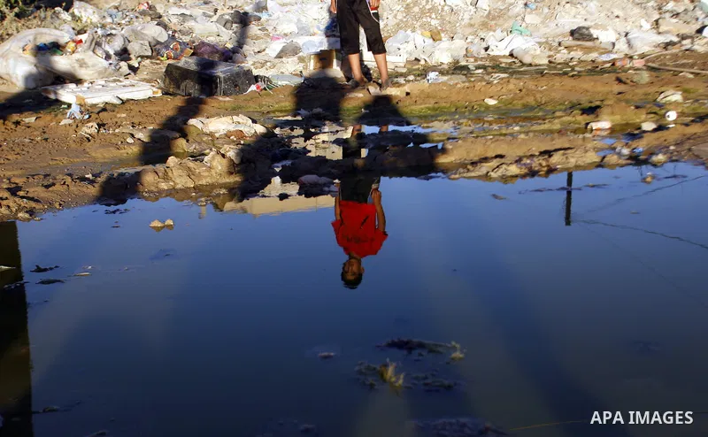 A Palestinian boy stands near an erupting sewage pipeline, in Rafah refugee camp southern the Gaza strip, Sept 26, 2012. In the aftermath of the Israeli military Operation Cast Lead in 2008/2009, Palestinian refugees in...