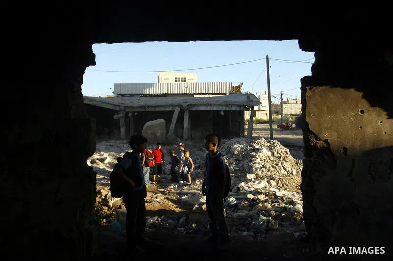 Palestinian students pass through an erupting sewage pipeline, in Rafah refugee camp southern the Gaza strip, Sept 26, 2012. In the aftermath of the Israeli military Operation Cast Lead in 2008/2009, Palestinian refugees...