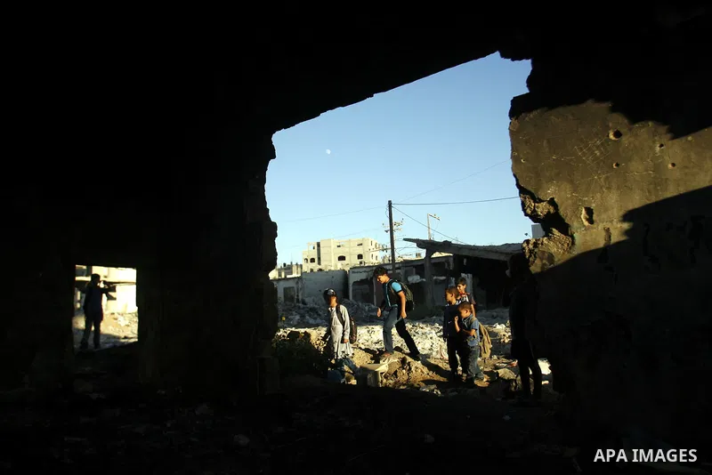 Palestinian students pass through an erupting sewage pipeline, in Rafah refugee camp southern the Gaza strip, Sept 26, 2012. In the aftermath of the Israeli military Operation Cast Lead in 2008/2009, Palestinian refugees...