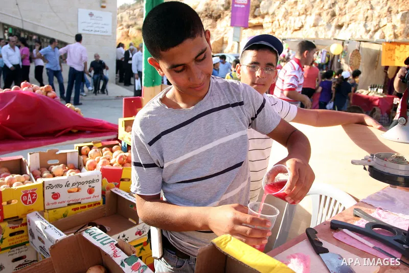 A Palestinian youth squeezes pomegranate fruits during the pomegranate festival in the village of Ein Arik near the West Bank city of Ramallah, Sept. 27, 2012. Photo by Issam Rimawi