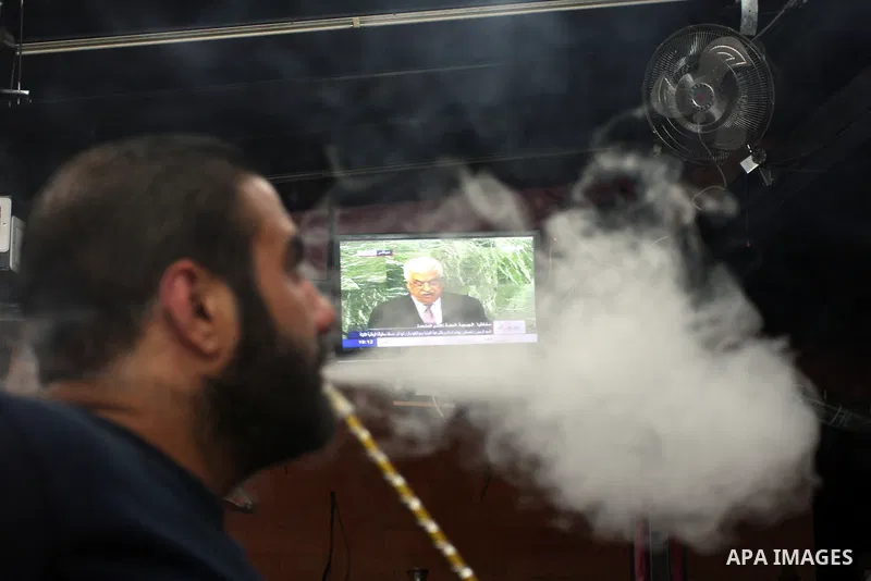 A Palestinian man smokes hookah at a cafe during the speech of Palestinian President Mahmoud Abbas at the at UN headquarters in New York in the 67th session of the United Nations General Assembly, in the West Bank city o...