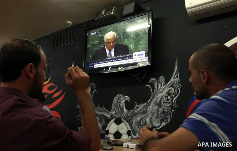 Palestinians watch TV during the speech of Palestinian President Mahmoud Abbas at the at UN headquarters in New York in the 67th session of the United Nations General Assembly, at a cafe in the West Bank city of Ramallah...