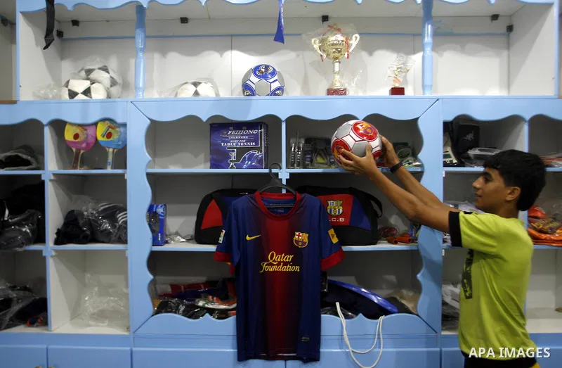 A Palestinian boy displays a football with the logo of Barcelona's soccer team at a sport store in Rafah in the southern Gaza strip, Sept. 27, 2012. Hamas is launching a media boycott of Barcelona after reports the Spani...