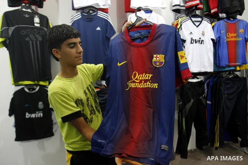 A Palestinian boy displays a shirt of Barcelona's soccer team at a sport store in Rafah in the southern Gaza strip, Sept. 27, 2012. Hamas is launching a media boycott of Barcelona after reports the Spanish league leader...
