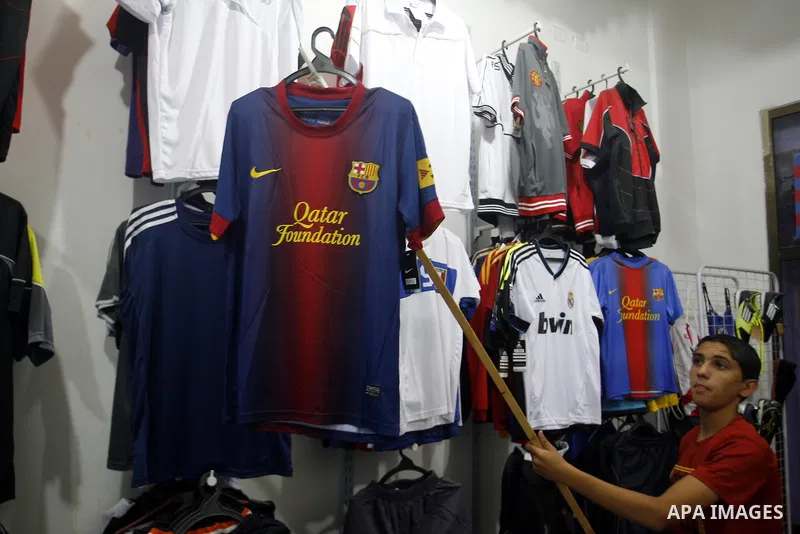 A Palestinian boy displays a shirt of Barcelona's soccer team at a sport store in Rafah in the southern Gaza strip, Sept. 27, 2012. Hamas is launching a media boycott of Barcelona after reports the Spanish league leader...