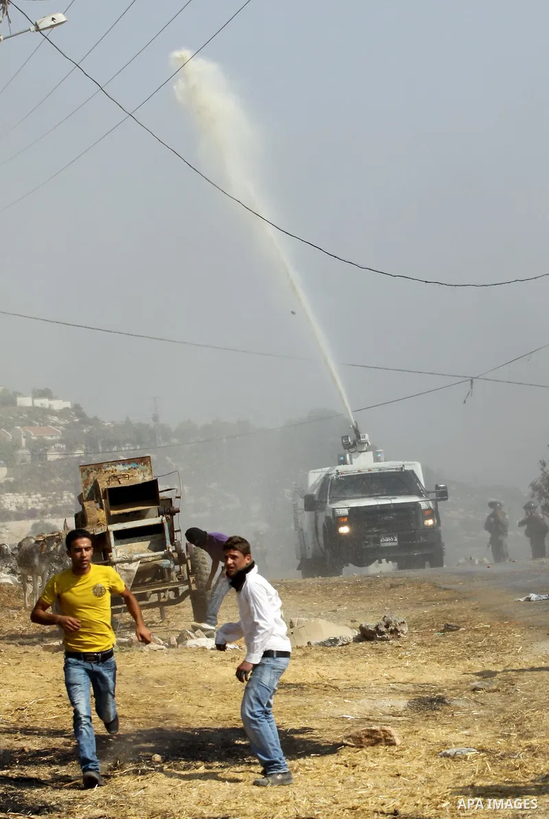 An Israeli truck spray foul smelling water towards Palestinian protesters after a demonstration against the expropriation of Palestinian land by Israel in the village of Kfar Qaddum, near the West Bank city of Nablus, on...