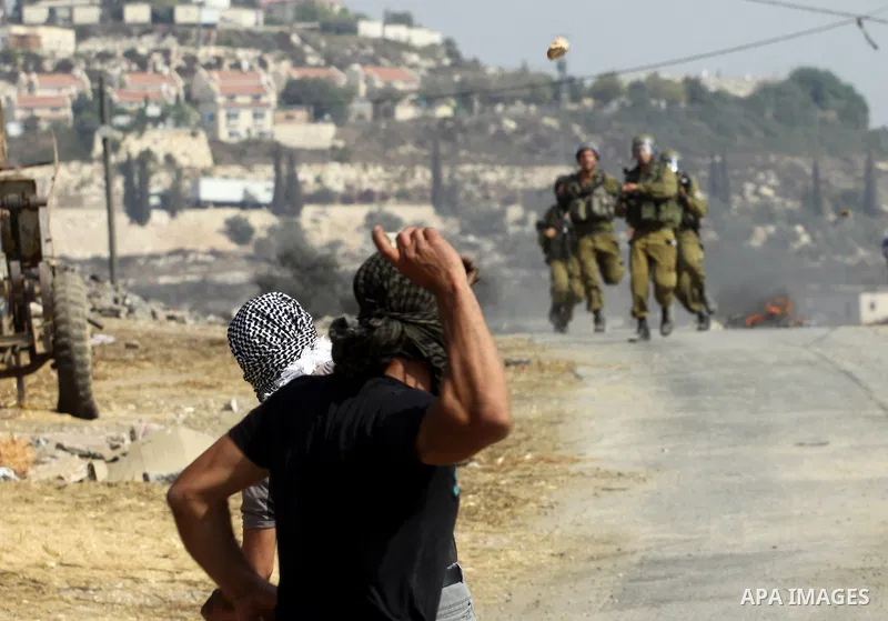 Palestinian protesters throw stones at Israeli troops after a demonstration against the expropriation of Palestinian land by Israel in the village of Kfar Qaddum, near the West Bank city of Nablus, on september 28, 2012....