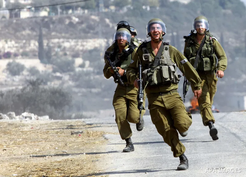 Israeli soldiers run follow Palestinian protesters after a demonstration against the expropriation of Palestinian land by Israel in the village of Kfar Qaddum, near the West Bank city of Nablus, on september 28, 2012. Ph...