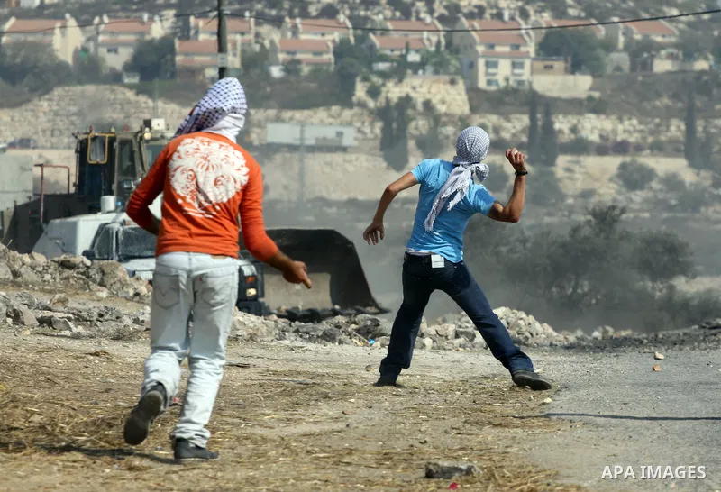 Palestinian protesters throw stones at Israeli troops after a demonstration against the expropriation of Palestinian land by Israel in the village of Kfar Qaddum, near the West Bank city of Nablus, on september 28, 2012....