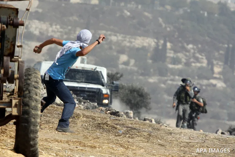 A Palestinian protester throws stones at Israeli troops after a demonstration against the expropriation of Palestinian land by Israel in the village of Kfar Qaddum, near the West Bank city of Nablus, on september 28, 201...
