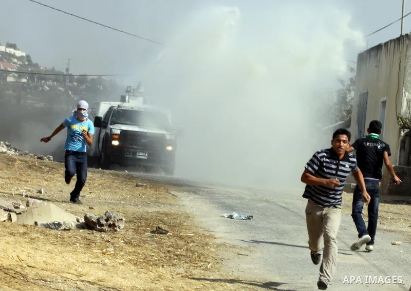 An Israeli truck spray foul smelling water towards Palestinian protesters after a demonstration against the expropriation of Palestinian land by Israel in the village of Kfar Qaddum, near the West Bank city of Nablus, on...