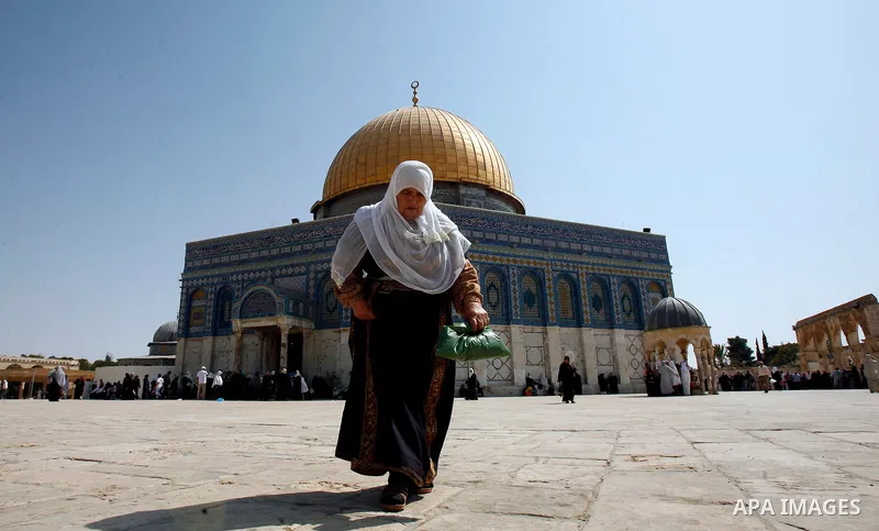 A Palestinan worshiper woman walks in front of the Dome of the Rock Mosque during the Friday prayers at al-Aqsa mosque compound in Jerusalem's old city on September 28, 2012. Photo by Mahfouz Abu Turk