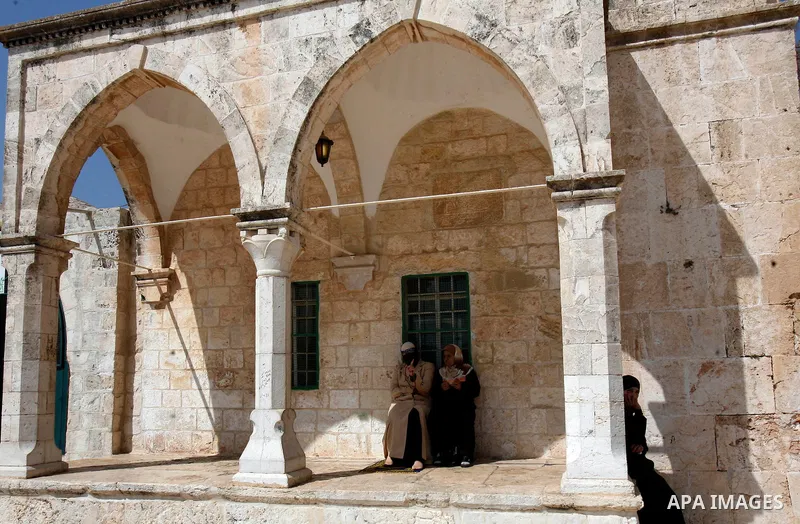 Palestinan worshipers sit in front of the Dome of the Rock Mosque during the Friday prayers at al-Aqsa mosque compound in Jerusalem's old city on September 28, 2012. Photo by Mahfouz Abu Turk