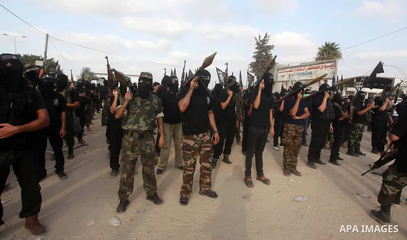 Palestinian militants from the Al Nasser Brigades, an armed wing of the Popular Resistance Committees (PRC) hold weapons during a rally marking the 12th anniversary of the brigades, in Gaza city, Friday, Sept. 28, 2012....