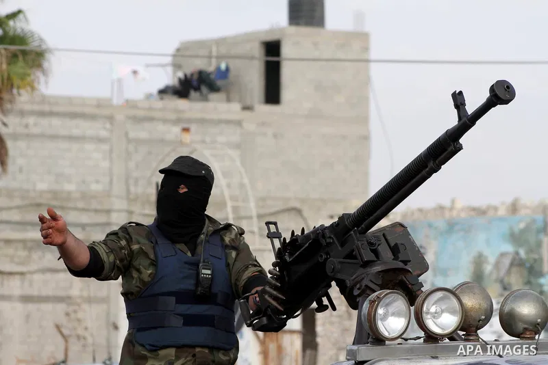 A Palestinian militant from the Al Nasser Brigades, an armed wing of the Popular Resistance Committees (PRC) holds a weapon during a rally marking the 12th anniversary of the brigades, in Gaza city, Friday, Sept. 28, 201...