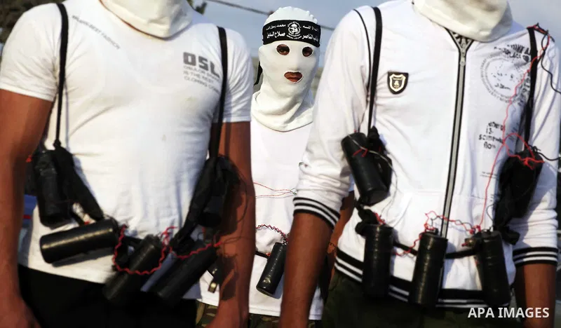 Palestinian militants from the Al Nasser Brigades, an armed wing of the Popular Resistance Committees (PRC) hold weapons during a rally marking the 12th anniversary of the brigades, in Gaza city, Friday, Sept. 28, 2012....