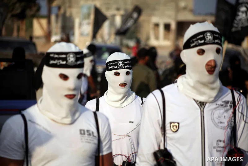 Palestinian militants from the Al Nasser Brigades, an armed wing of the Popular Resistance Committees (PRC) hold weapons during a rally marking the 12th anniversary of the brigades, in Gaza city, Friday, Sept. 28, 2012....