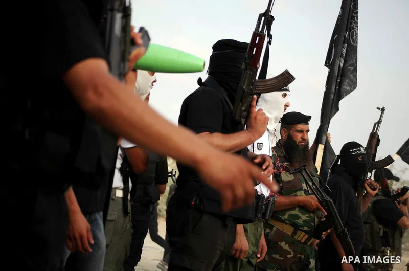 Palestinian militants from the Al Nasser Brigades, an armed wing of the Popular Resistance Committees (PRC) hold weapons during a rally marking the 12th anniversary of the brigades, in Gaza city, Friday, Sept. 28, 2012....