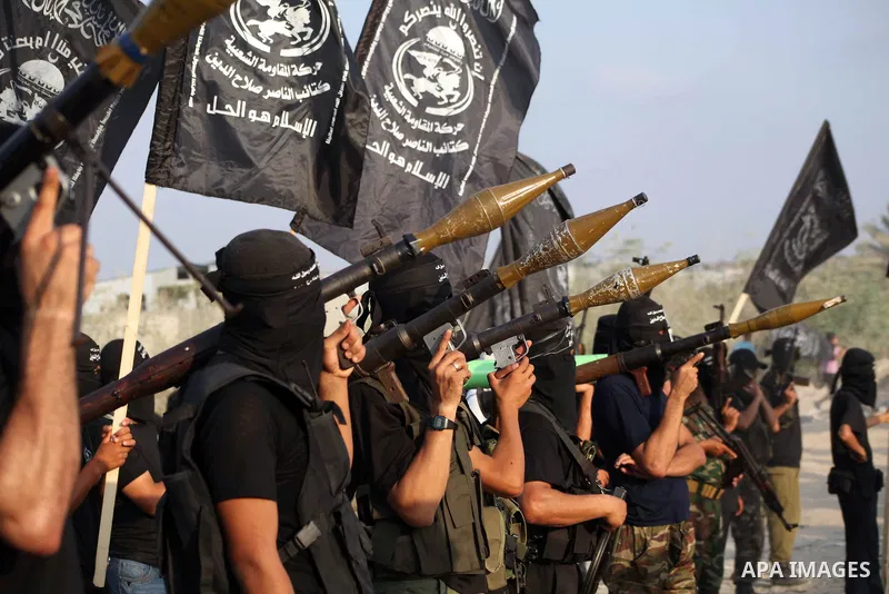 Palestinian militants from the Al Nasser Brigades, an armed wing of the Popular Resistance Committees (PRC) hold weapons during a rally marking the 12th anniversary of the brigades, in Gaza city, Friday, Sept. 28, 2012....